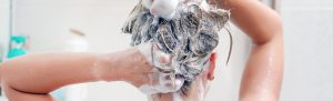 woman lathering hair with shampoo